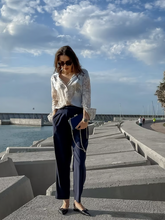 a lady wears a silk shirt with loose fit pants